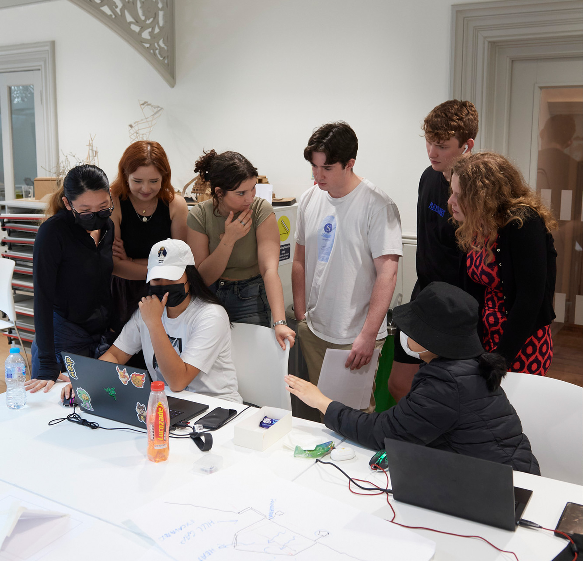 Architecture students gathered round a laptop