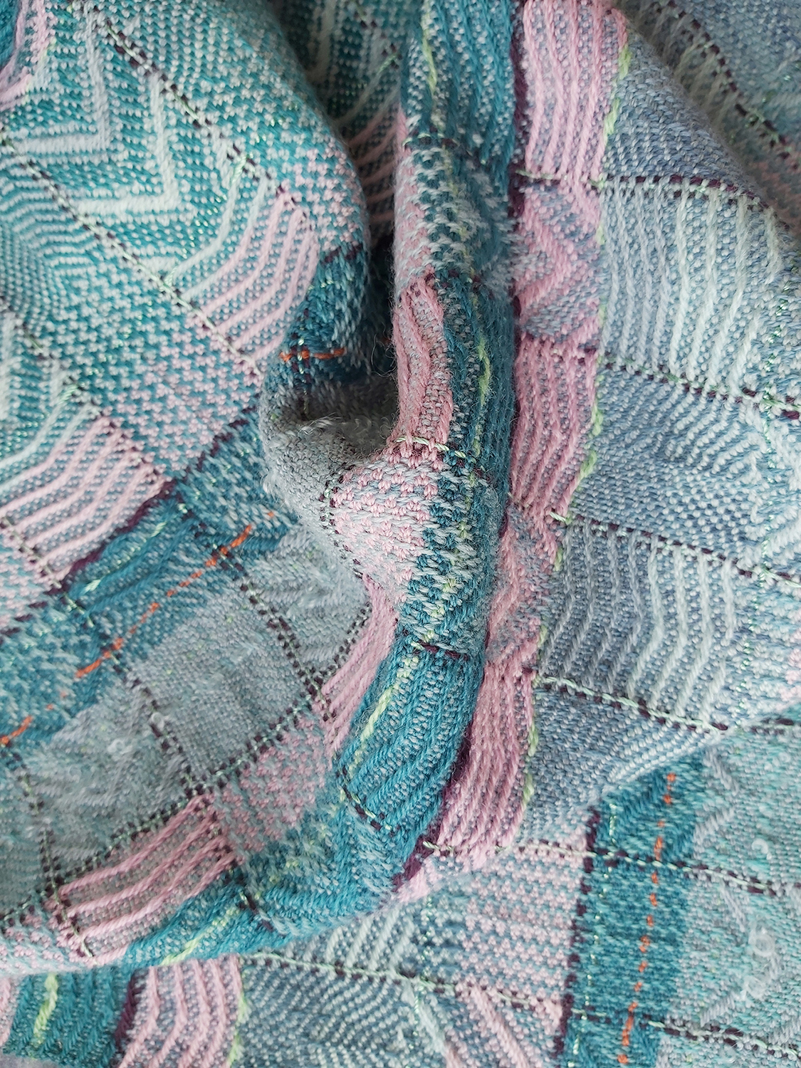Woven fabric with vertical pattern stripes and horizontal colour stripes, in turquoise, lavender, plum and pale blue.