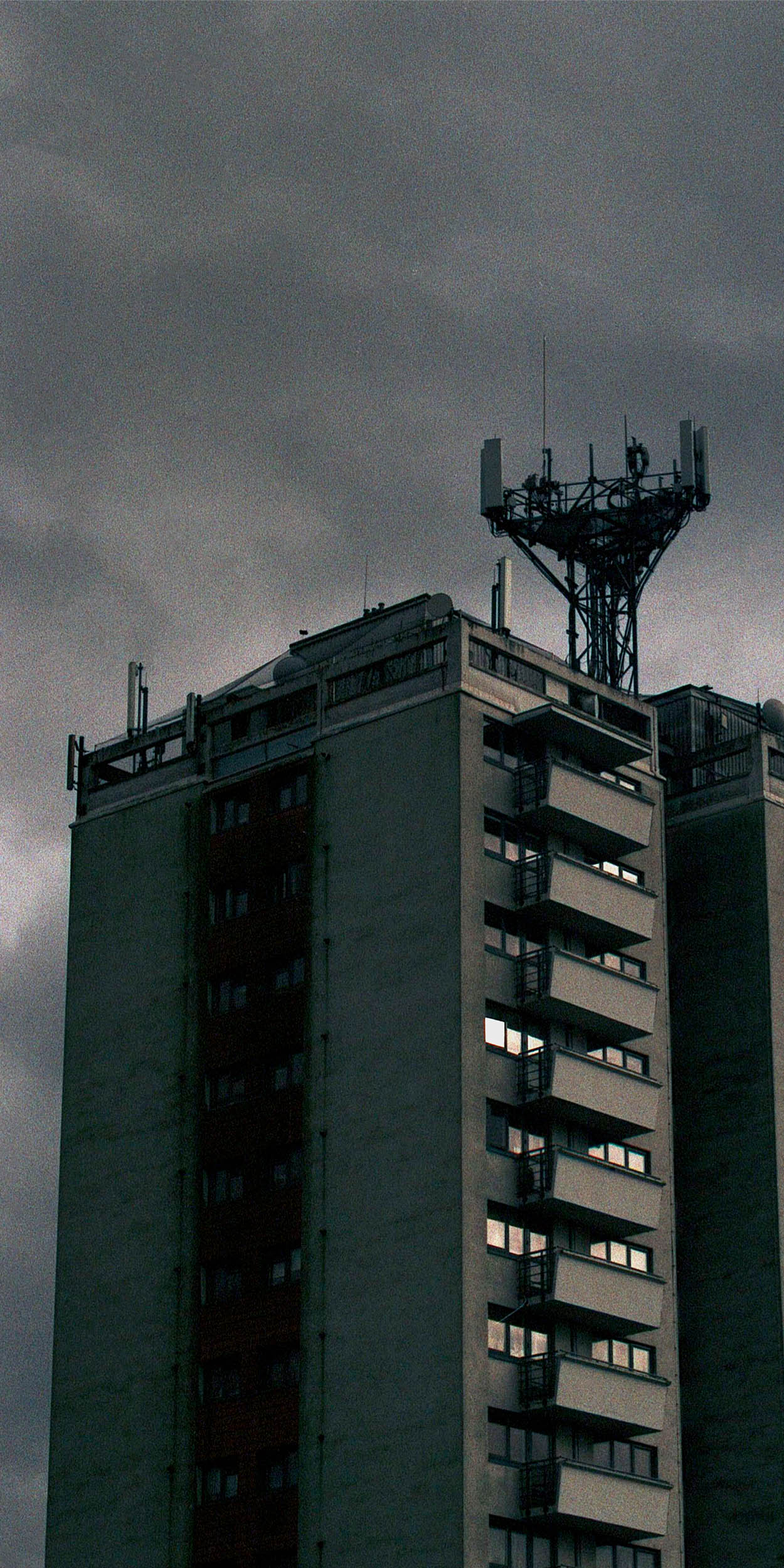 Ba Fine Art work by Brandon Tilley showing a clouded scene, with a dim lit set of tower block flats