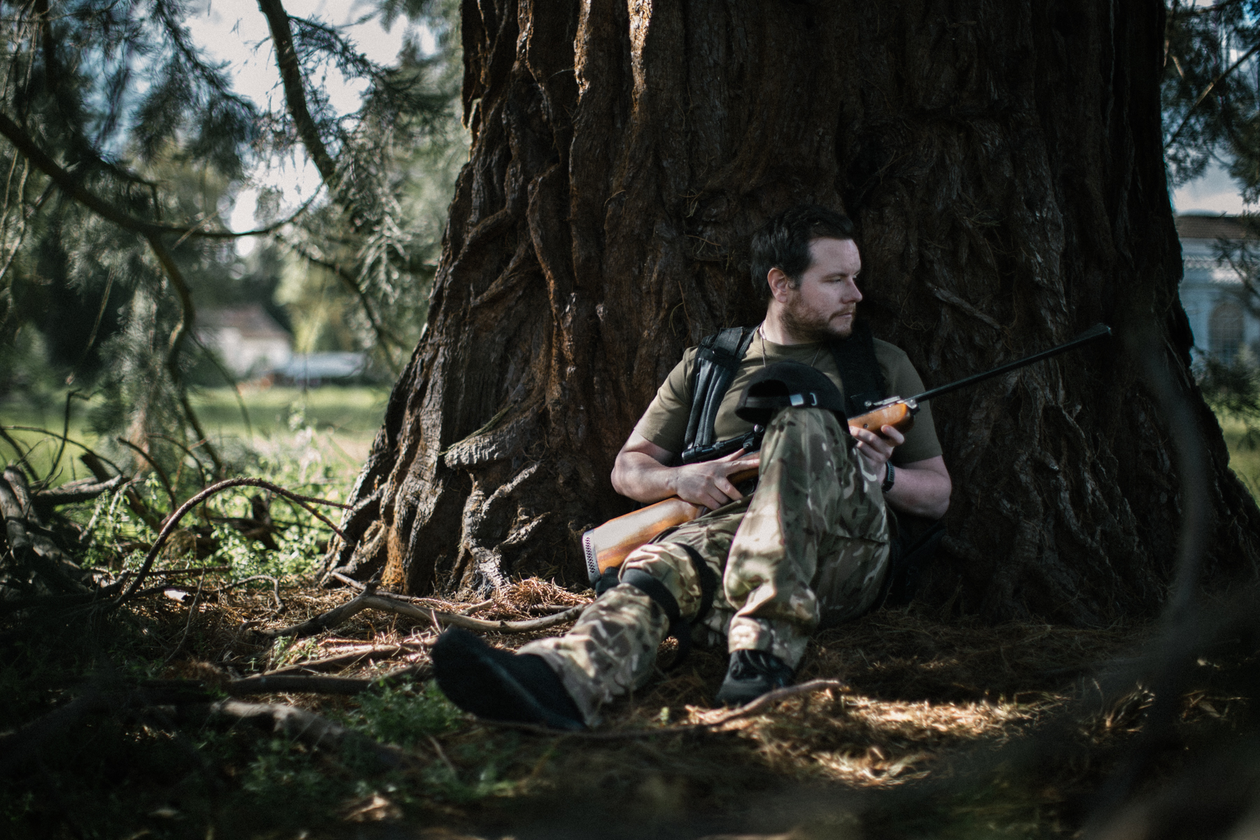 BA Photography work by Callum Broomhead showing a JPEG image of a sniper taking cover behind a large tree.