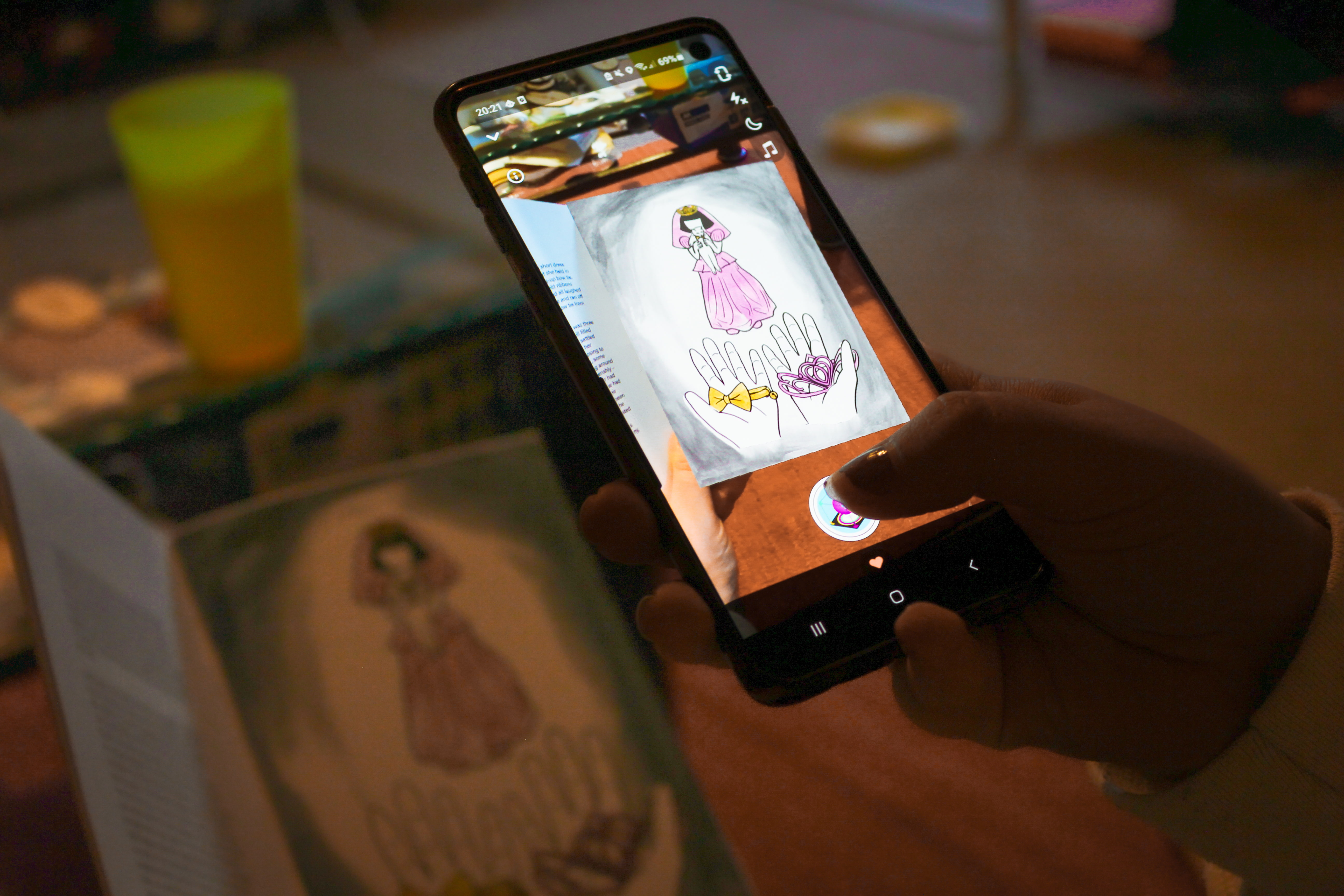 Photograph of a phone scanning an inside page of the zine to show an animated version of the page giving the viewer the visual movement of the image.