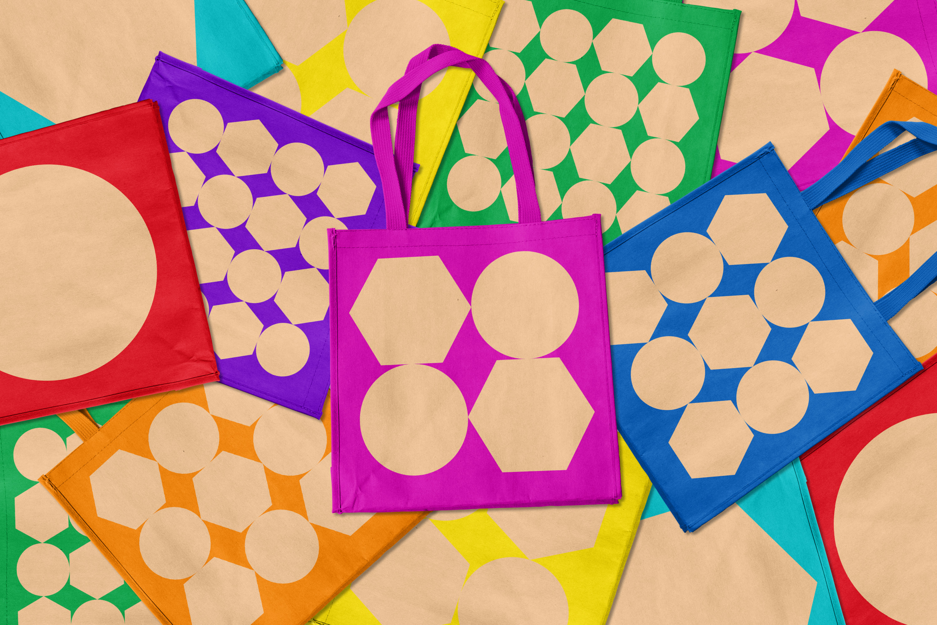 Graphic Communication work by James Keeley showing Derwent Pencil Museum Tote Bags, in vibrant colours, with neutral shapes of pencil ends in hexagon and circles.