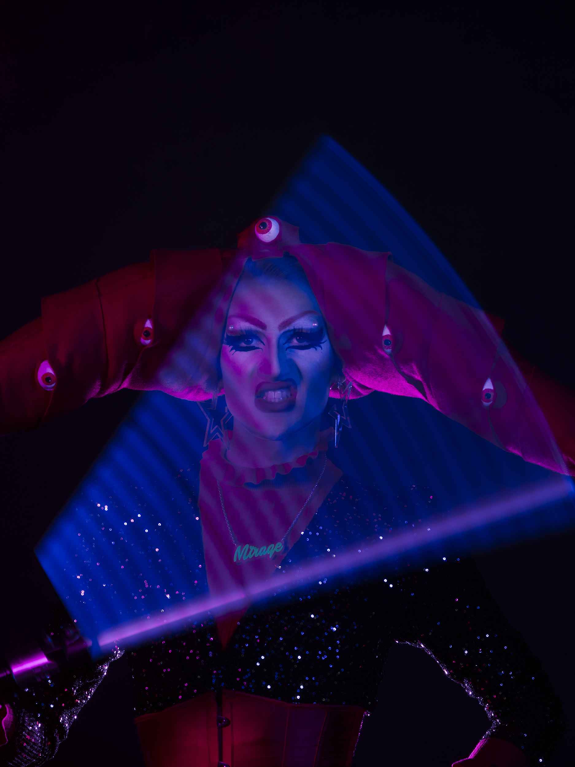 BA Photography work by Micha Hollis showing a portrait of drag artist Blue Monday. The lighting is multi-coloured with pink on the left and blue on the right.