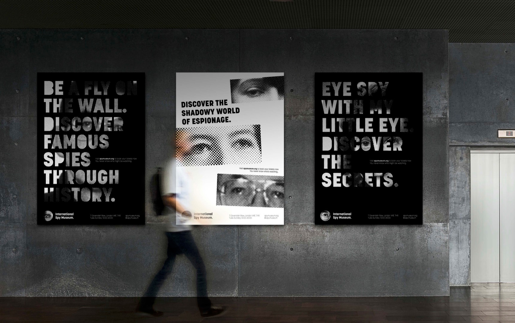 Three posters shown in context on a dark grey wall, showcasing the museum and specific exhibitions.