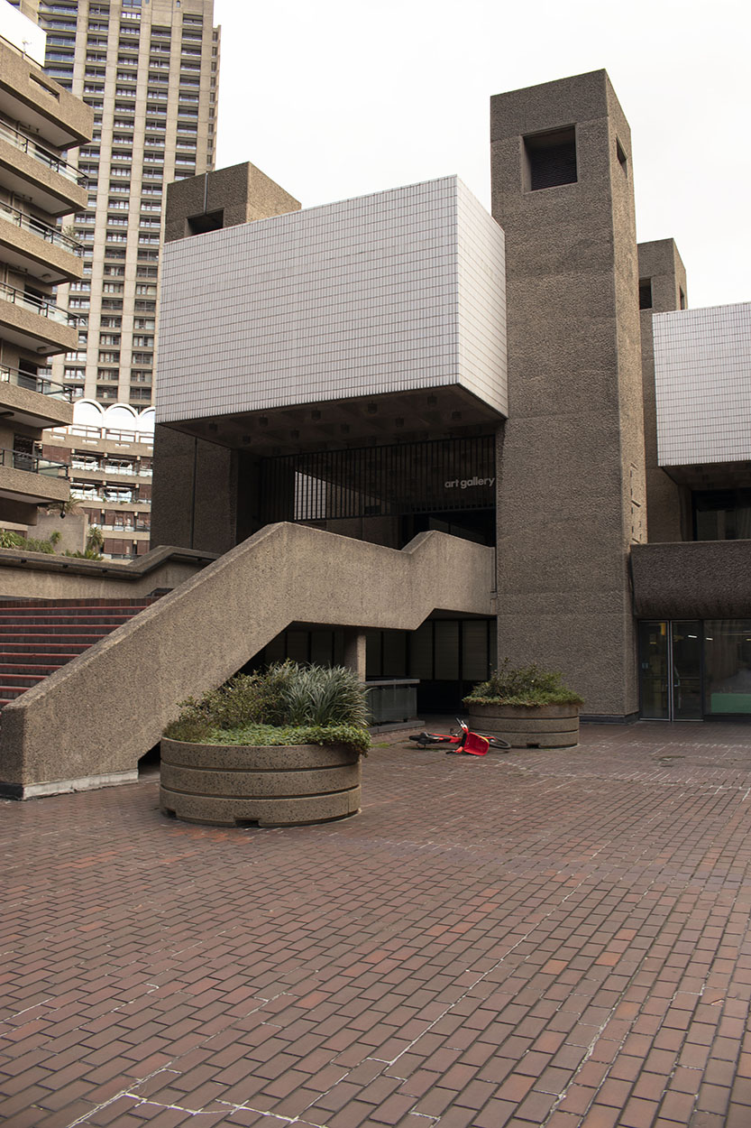 Brutalist architecture image by Becca Simmons showing a red bike that was left surrounded by the architecture.