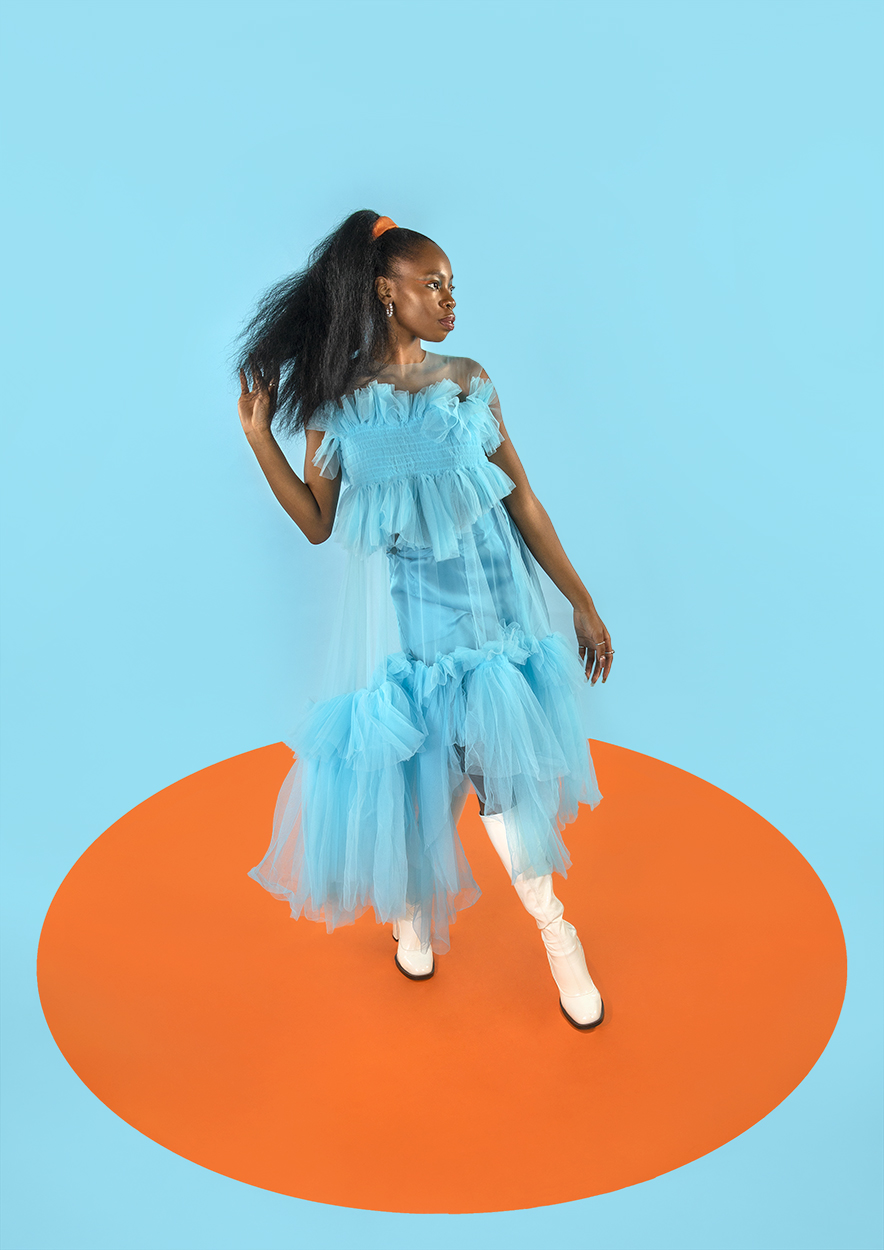 BA Photography work by Becca Stevenson showing a girl in a blue, tulle dress against a blue backdrop, standing in an orange circle.