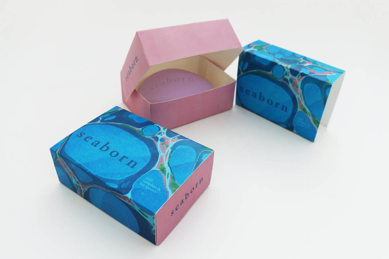 BA Graphic Design work by Rose Taylor-Townshend showcasing a soap box design named‚ Seaborn. the outer layer has a water marble design in various blues, greens and purples.