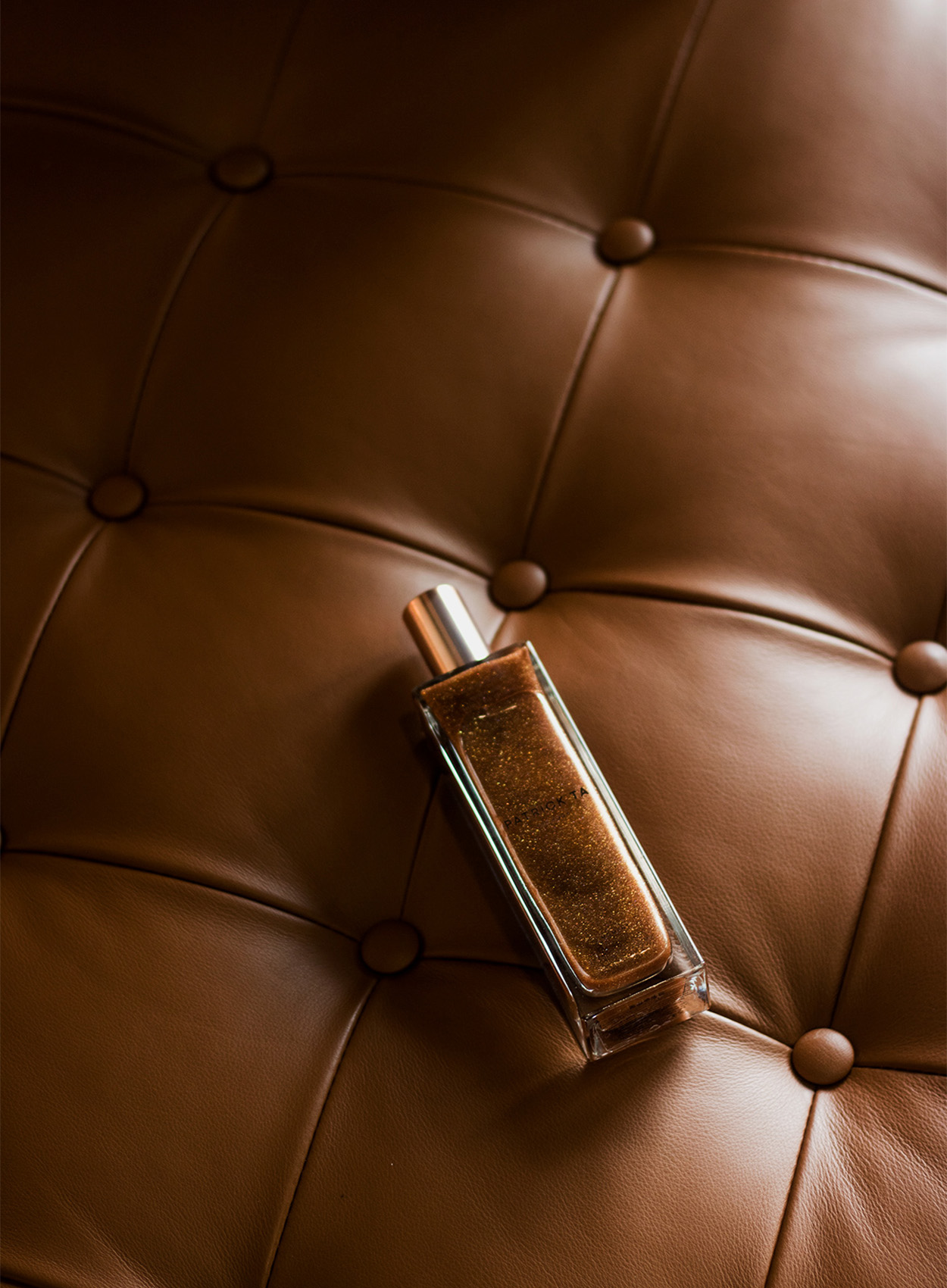 BA FCP work by Tara Lea. mage displays an editorial image of a product bottle against luxury brown leather.