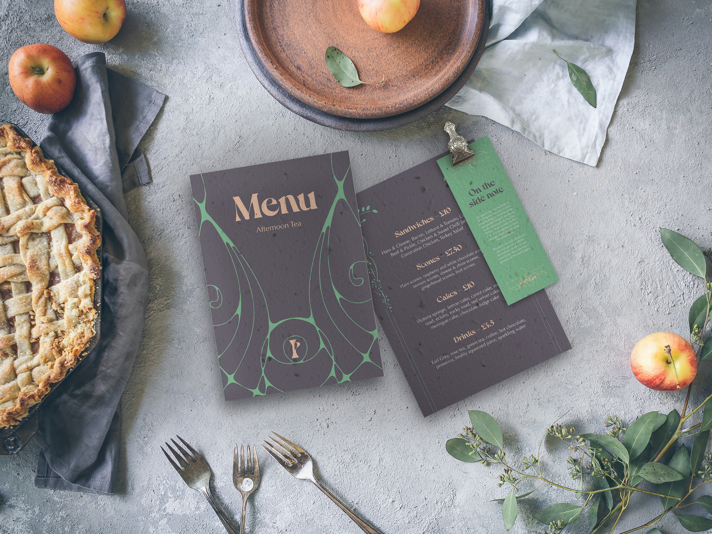 A mockup of a food menu on a table, surrounded by food, cutlery and foliage