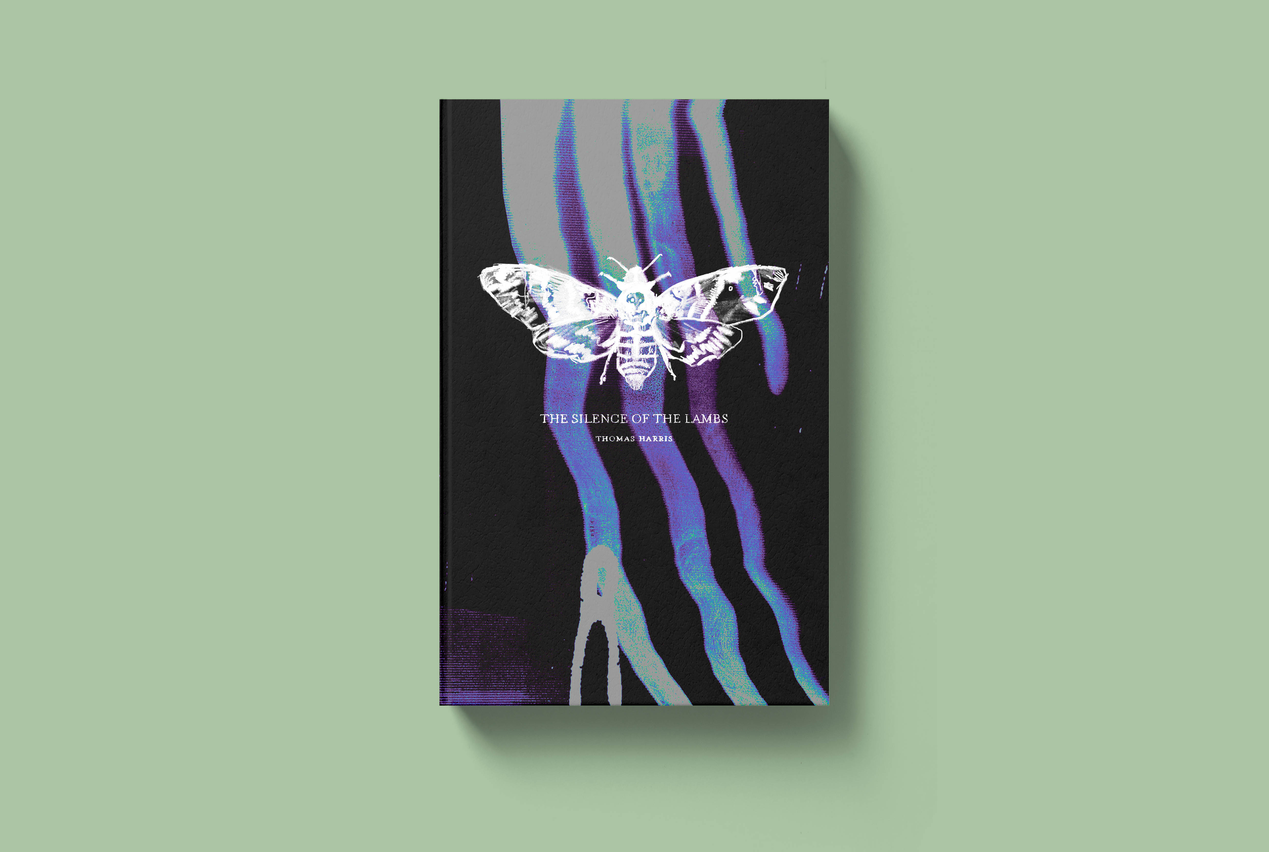 A digital mockup of a hardback book cover for The Silence of the Lambs. The cover is black with elements of purple and blue, with a white hand-drawn death's head hawk moth in the centre.