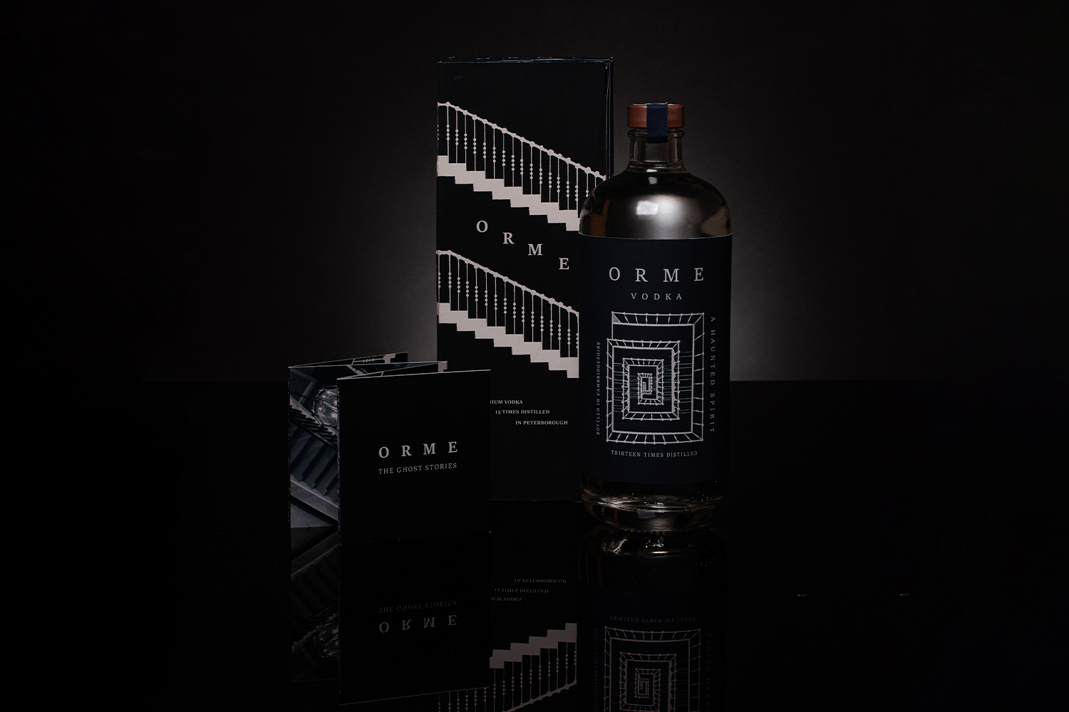 A photo of a leaflet, bottle and box for Orme Vodka. All following the illustrative spiral staircase theme.
