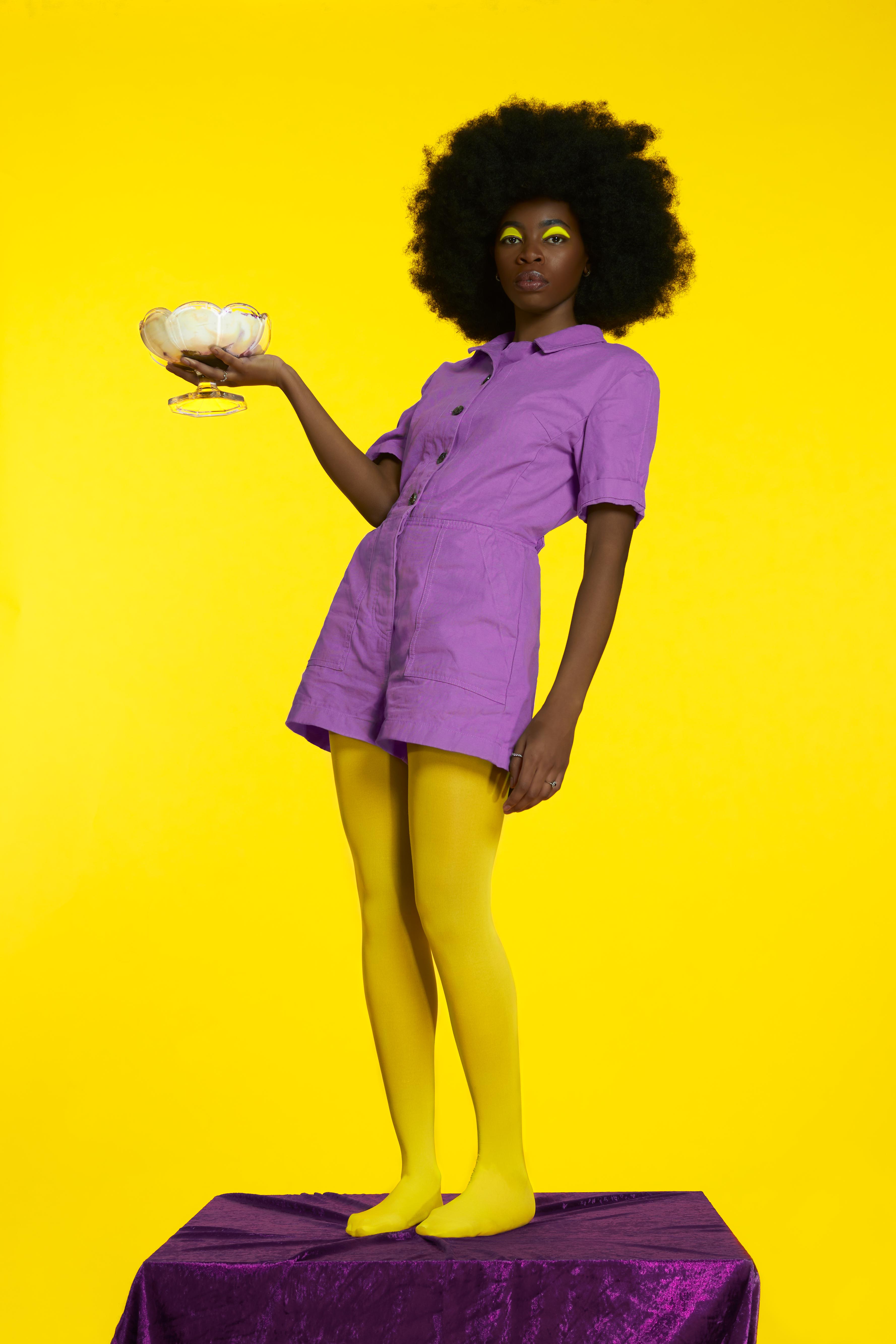 Fashion Editorial by Adam Billings showcasing a model dressed in purple against a yellow background.