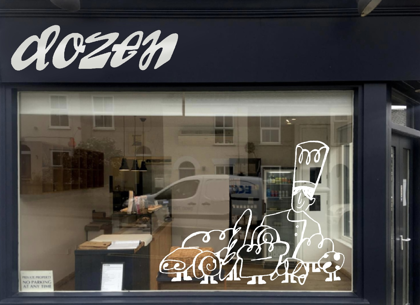 Bakery shopfront by Andrea Hammersley showing illustrated baked goods and chef character as a window display and a sign made from swirling typography.