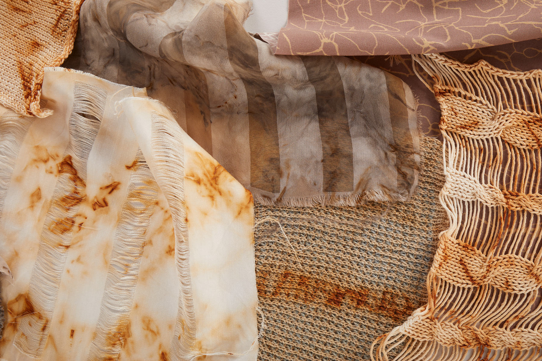 A photograph showing an array of rust dyed sample fabric.