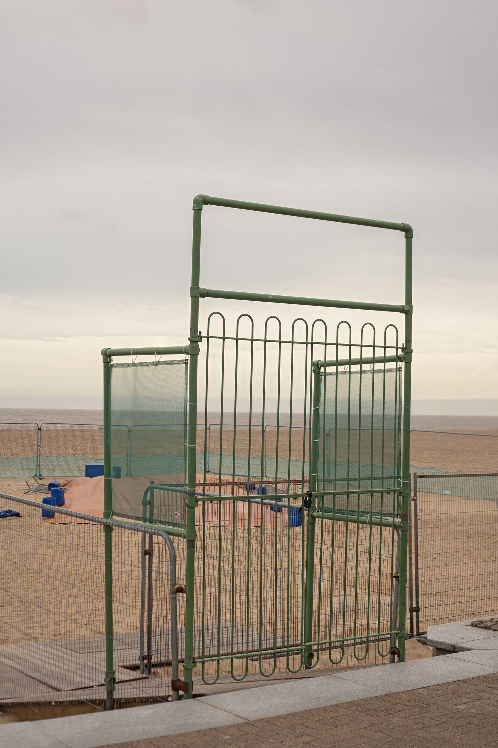 Photograph by Cerys Leahy depicting a gate to an out of use beach play area.