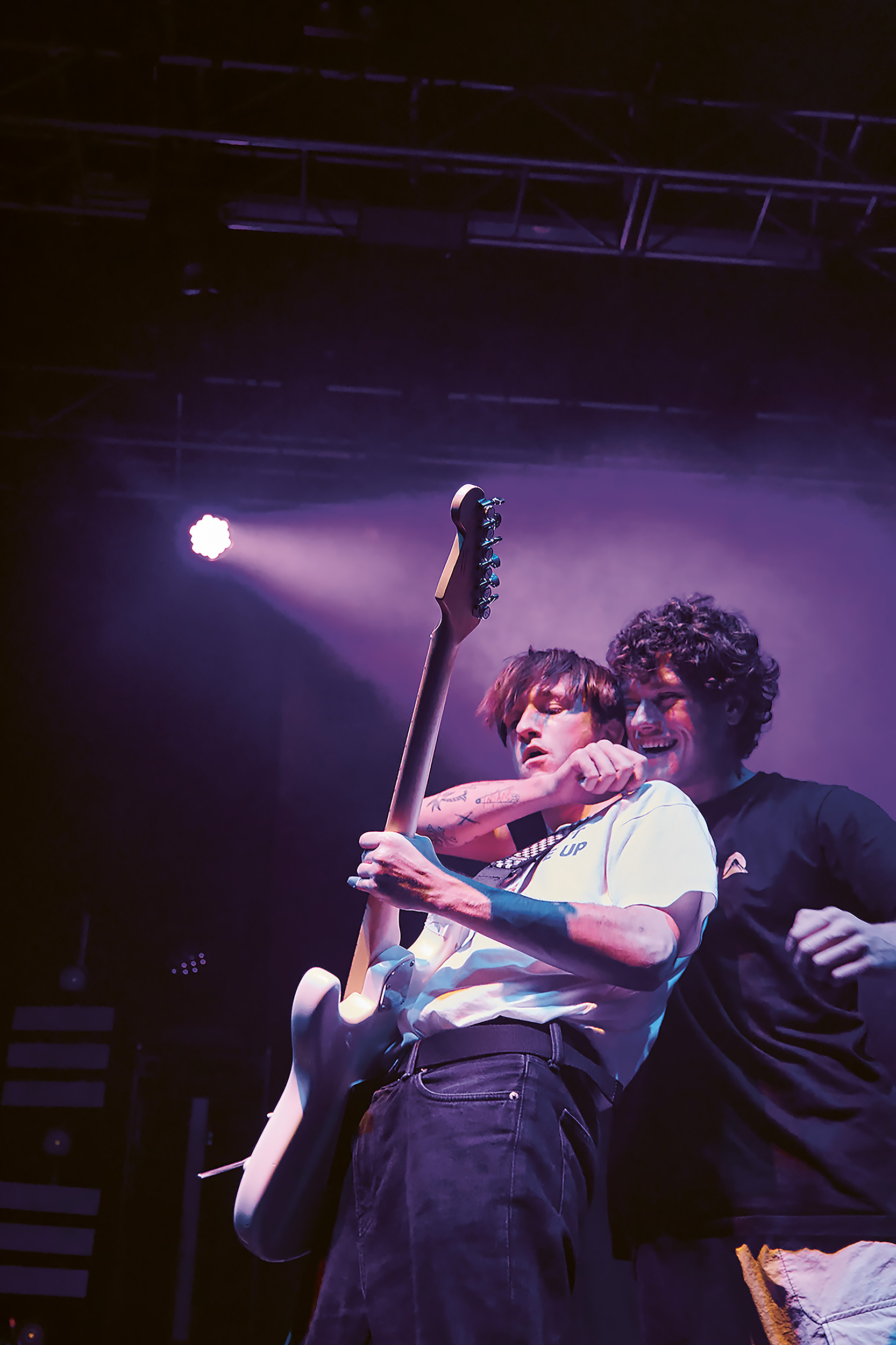 Live Music Photography image by Chloe Sibley depicting the singer hugging the guitarist on stage, smiling