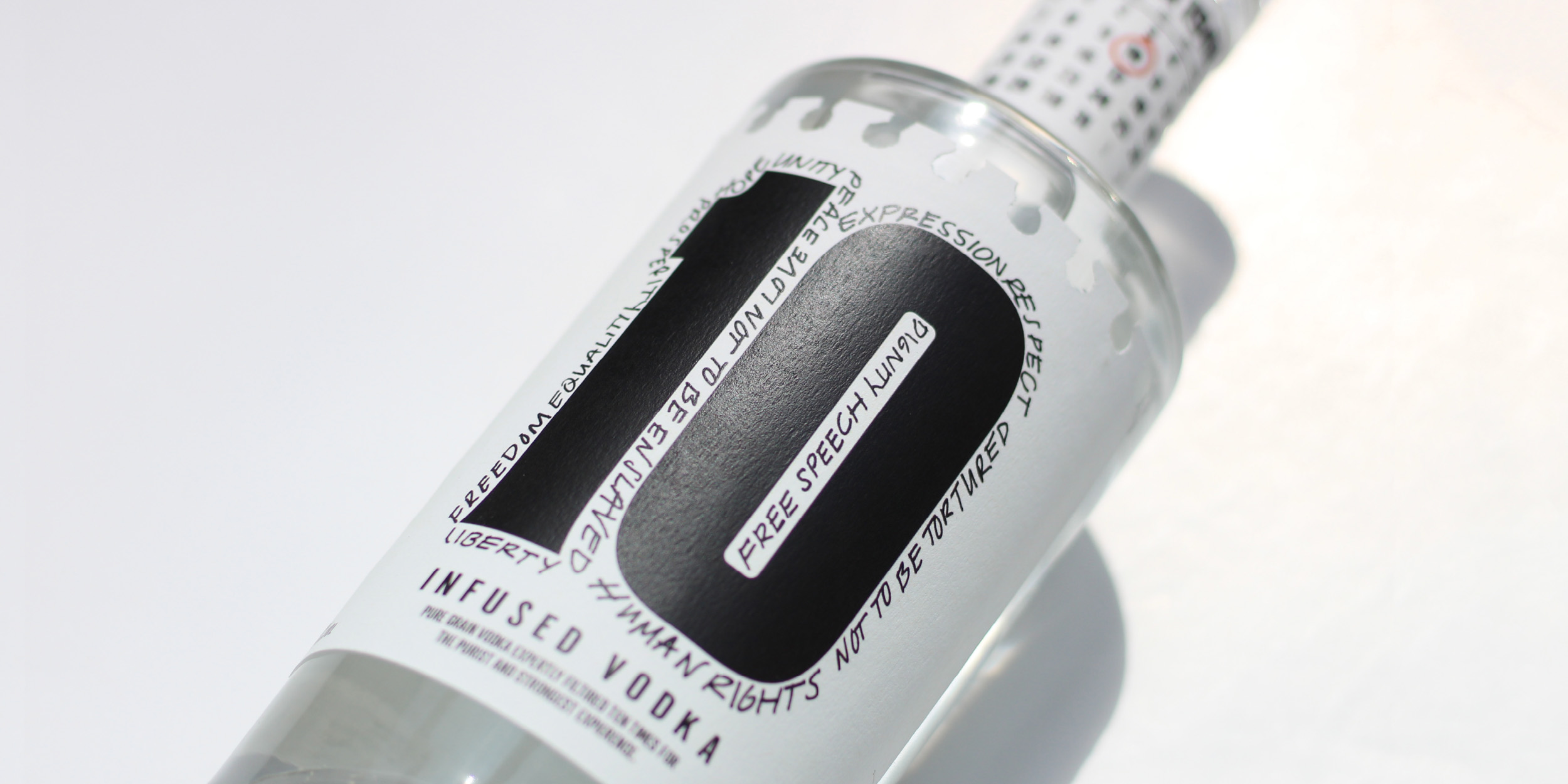 Design work by Cian Paige, showing a close-up shot of the bottle, showcasing the illustrated human rights around the logo.