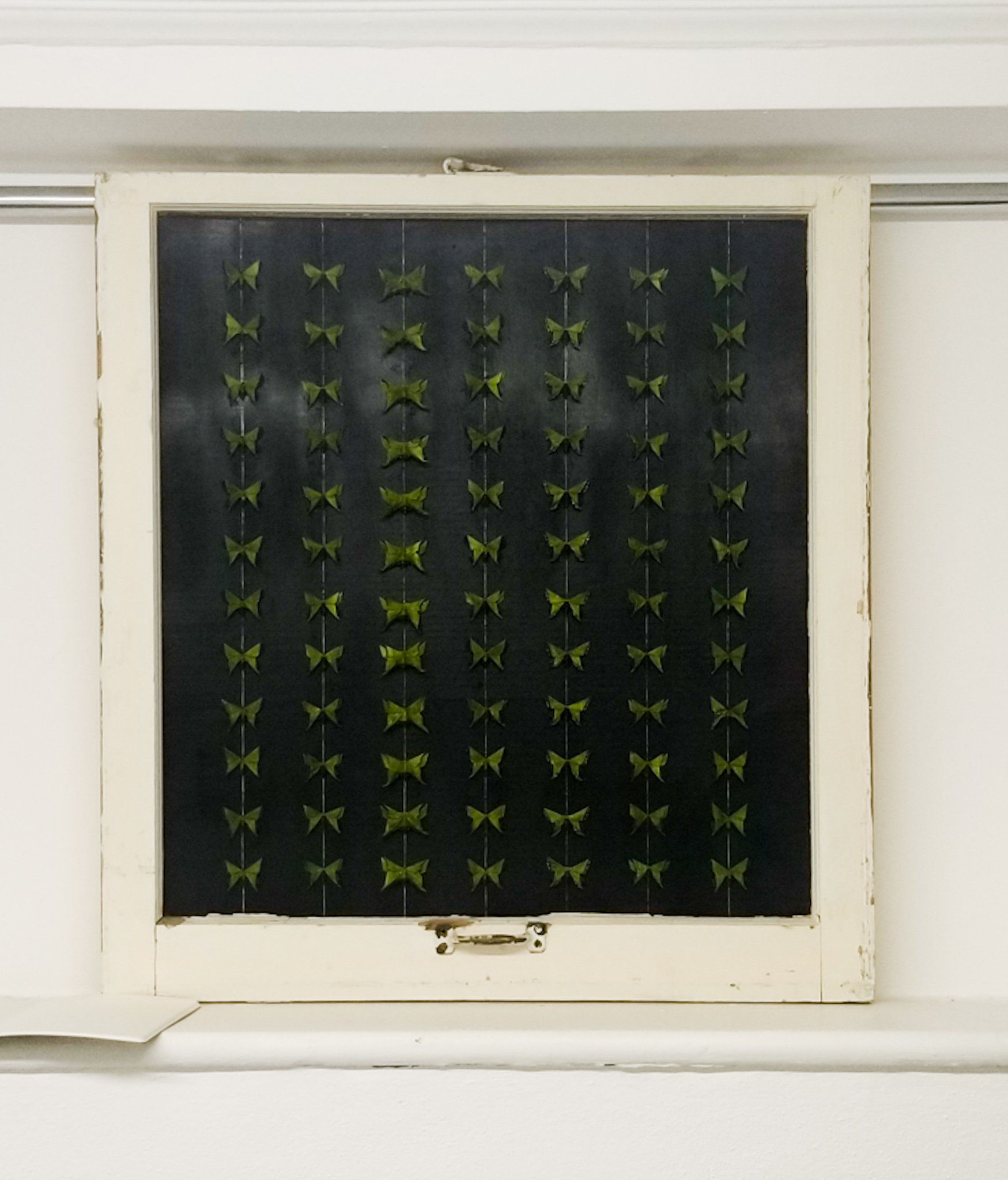 Fine Art work by Cydnee Inmon showing 90 green origami butterflies lined up in a farmhouse window frame.