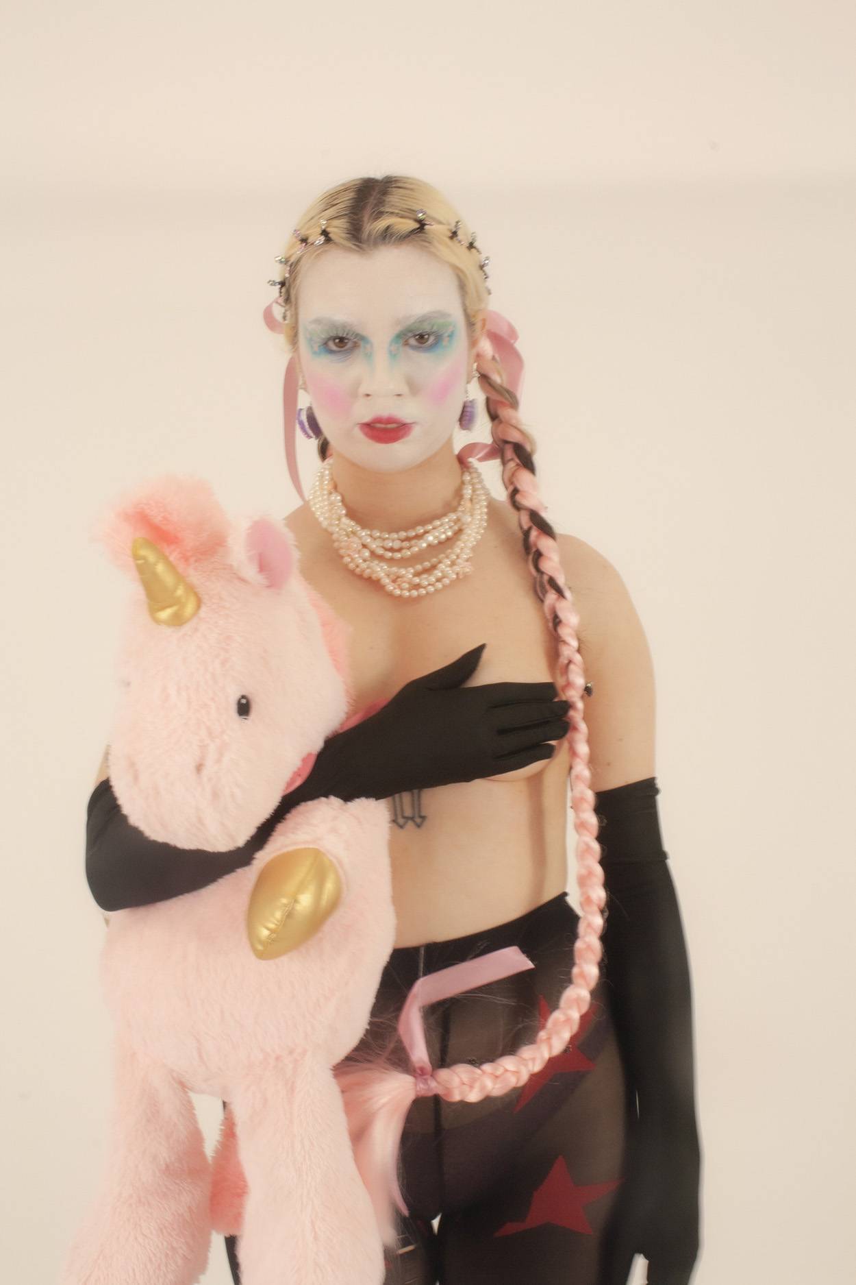 Photo of model holding unicorn soft toy from the series Modern Club Kids. Styling creative direction and photography by Grace Clayton, Makeup and Hair by Lucy Amos.