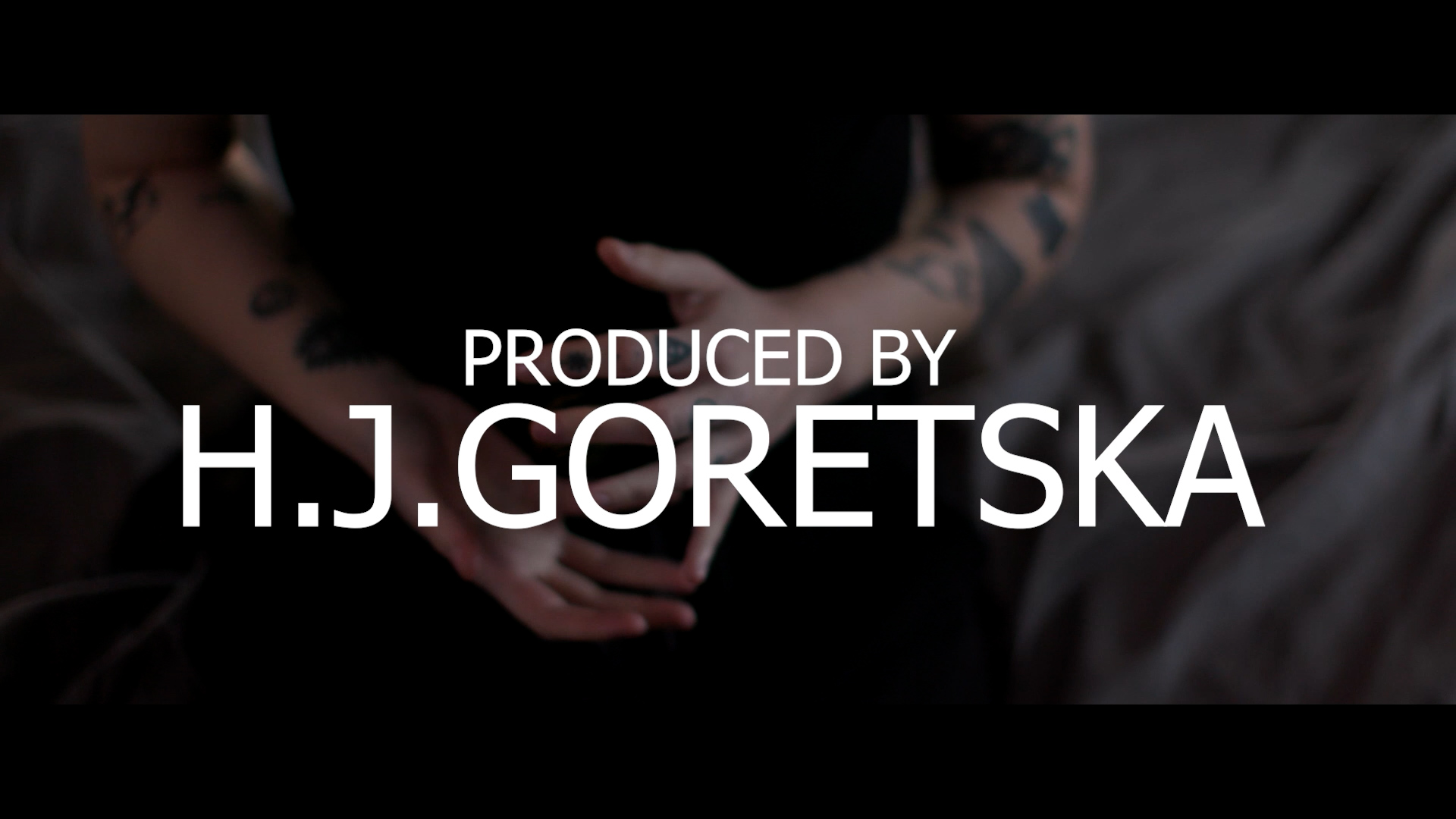 Image link to showreel by Holly Goretska, showing the range of final films she produced during her final project. Image shows the arms of a character with the title Produced by H.J. Goretska