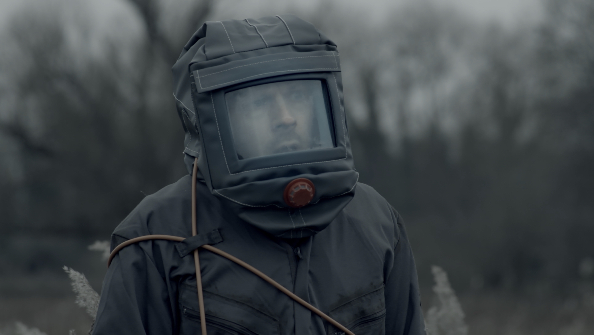 Production Design work by Isabelle Wheatland. A still image of one of her graduate films 'Alive' showing a man in a spacesuit standing in a field.
