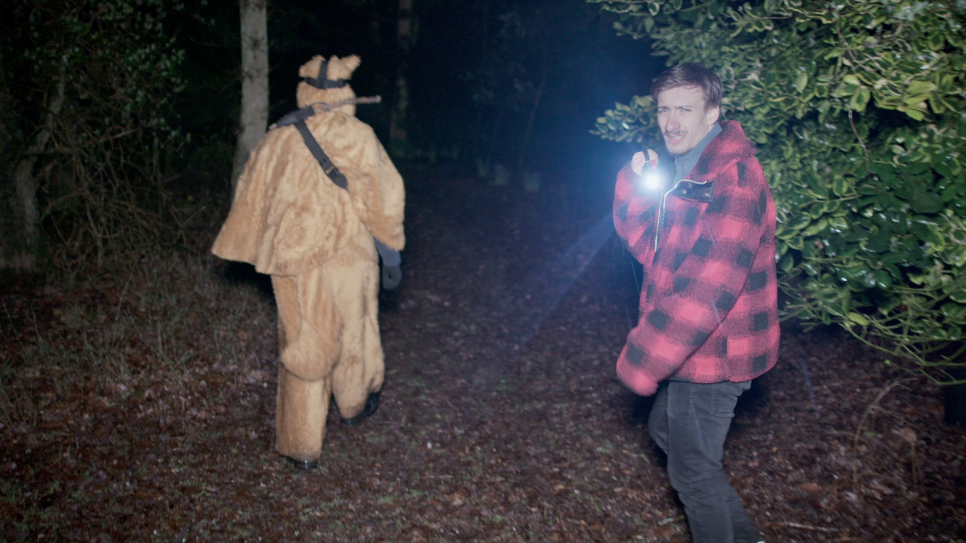 Image link to filmmaking showreel showing a plethora of work by Jack McKenna. Image shows two characters walking through a wooded area at night with a flashlight