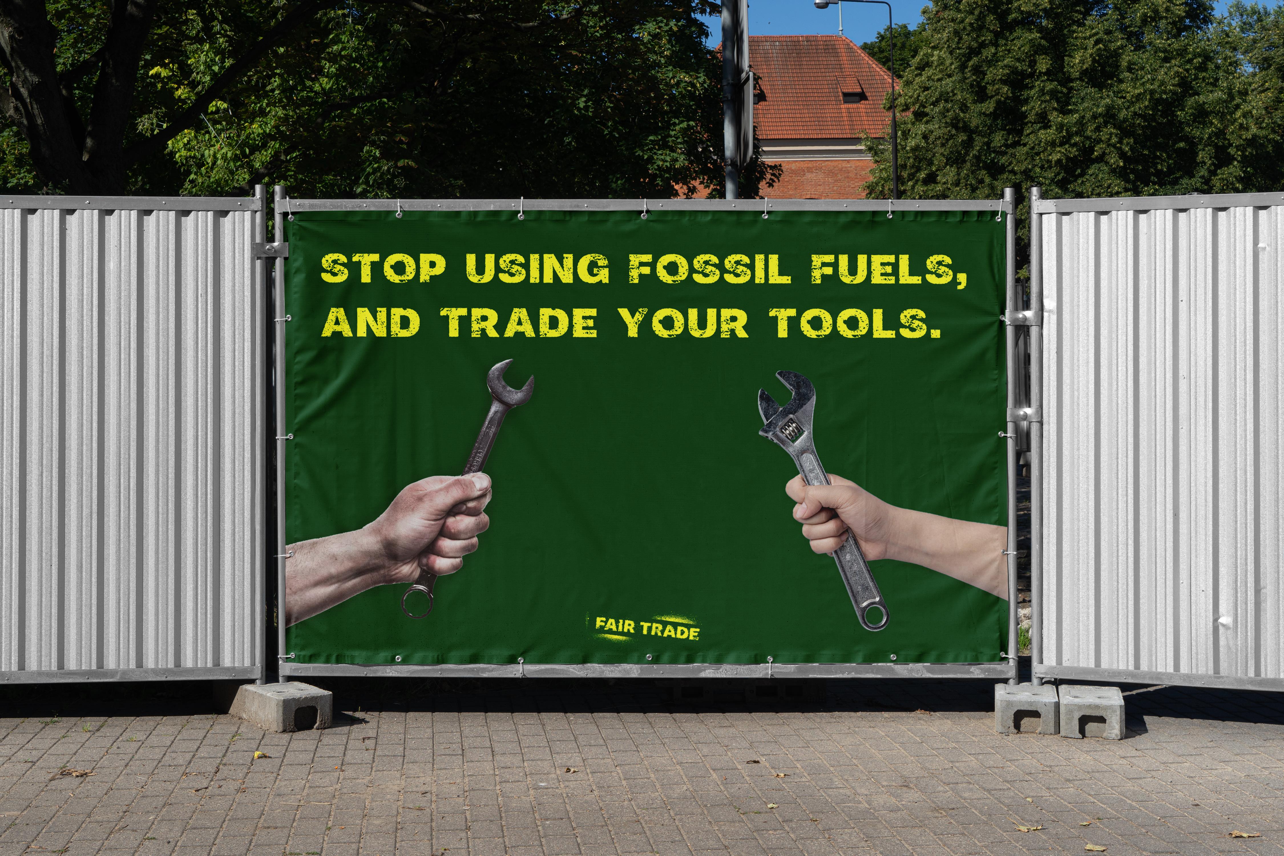 Dark Green Billboard for the hardware shop Fair Trade, with bold typography in yellow at top with hands holding tools on left and right.