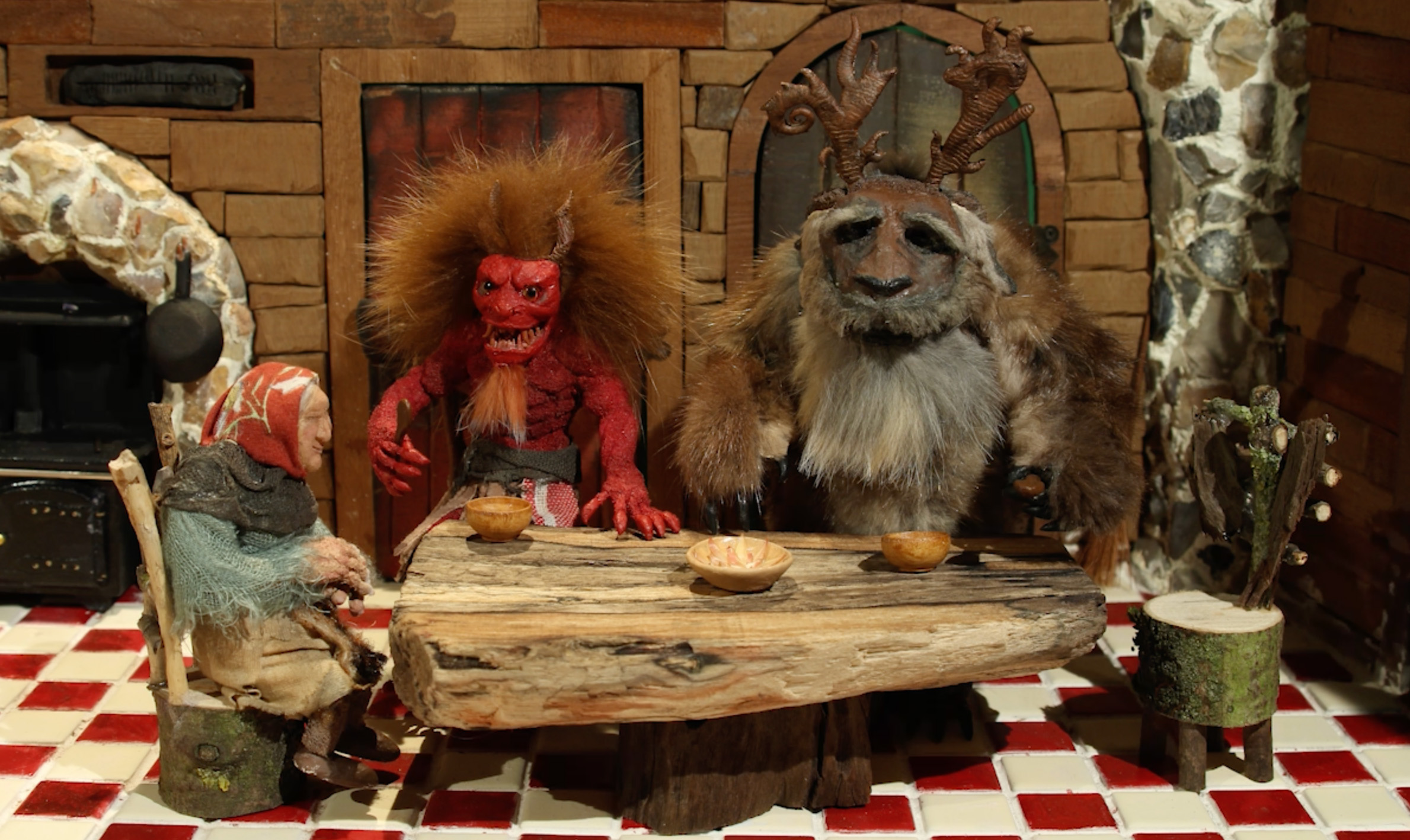 Scene from Stop Motion animation by Joseph Xotta, showing three puppets eating together at a table.