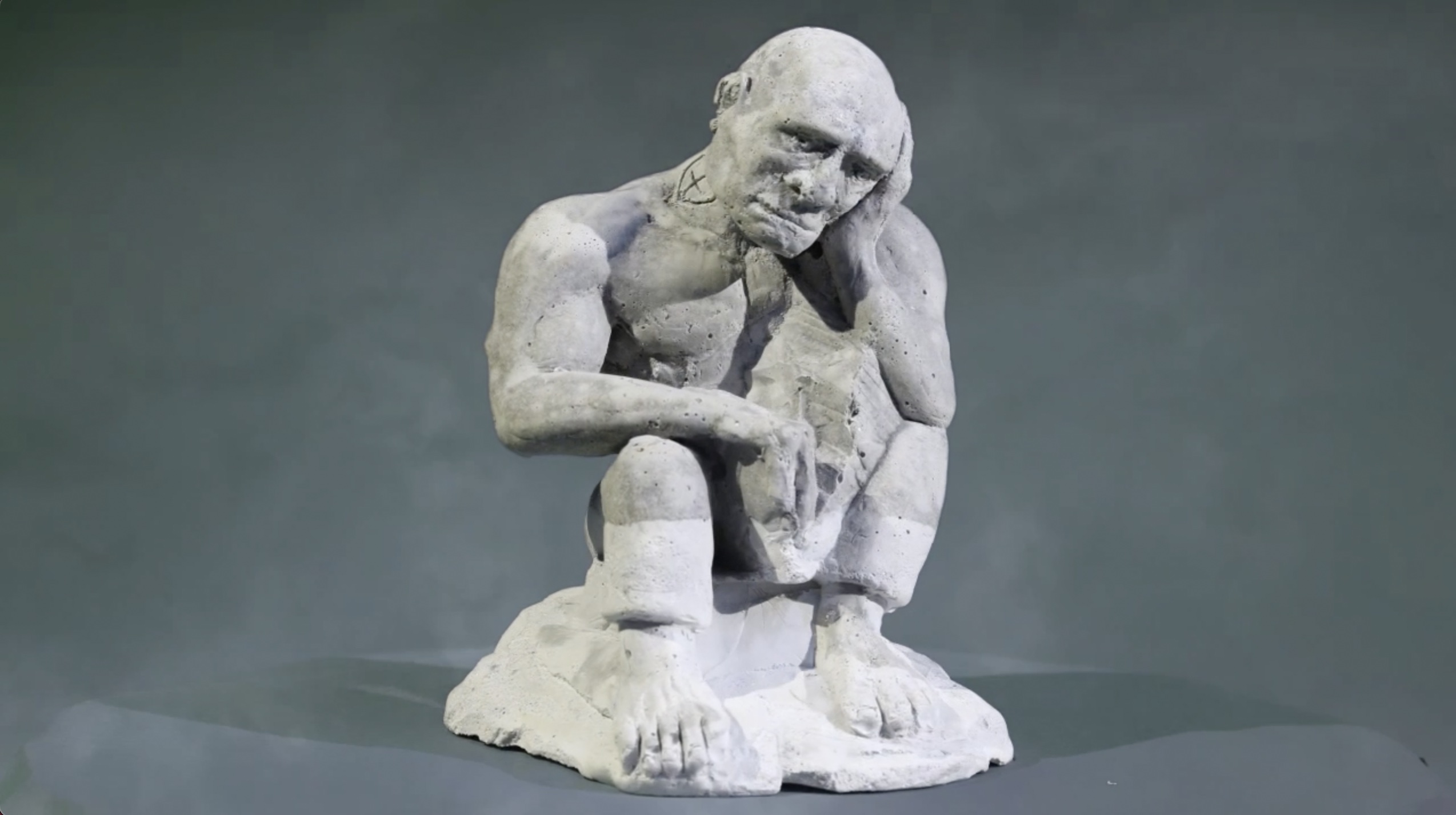 A turnaround of a sculpture by Joseph Xotta, showing a man with his head in his hand in sorrow.