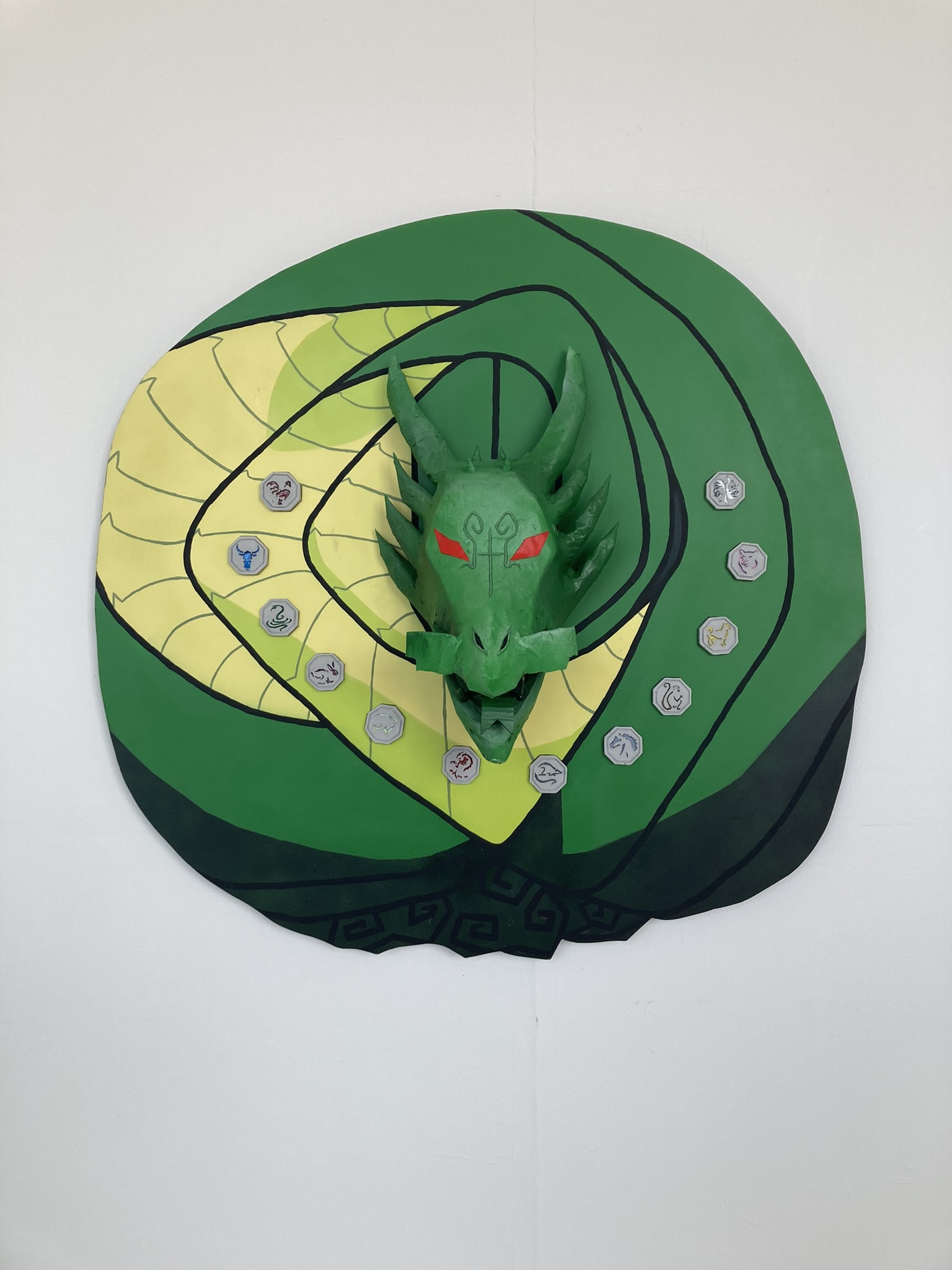 Fine Art work by Joy Suddery showing a coiled green dragon sculpture with twelve octagonal objects inserted into the body of the dragon.