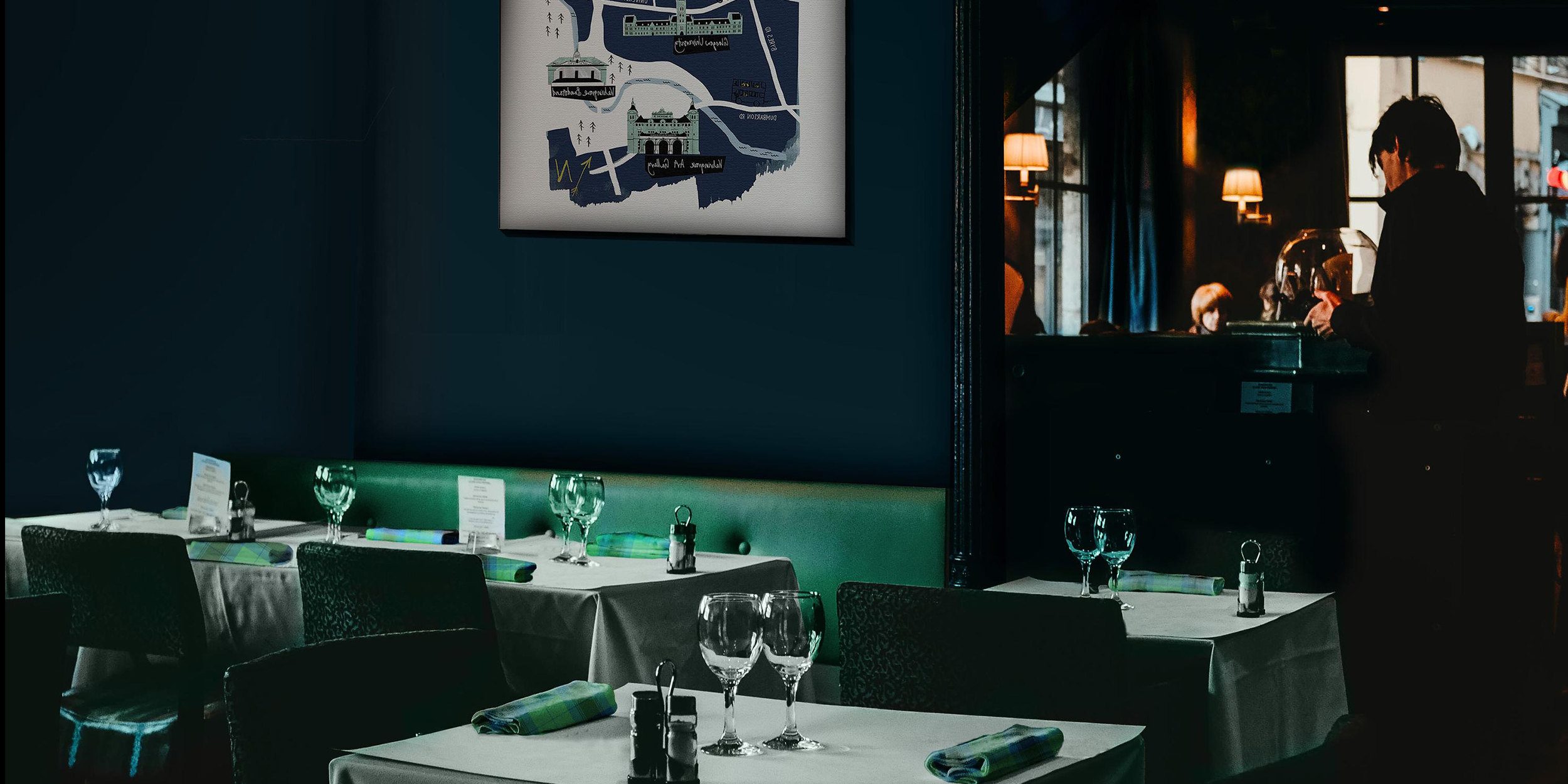 Restaurant scene featuring tartan napkins and upside down artwork.