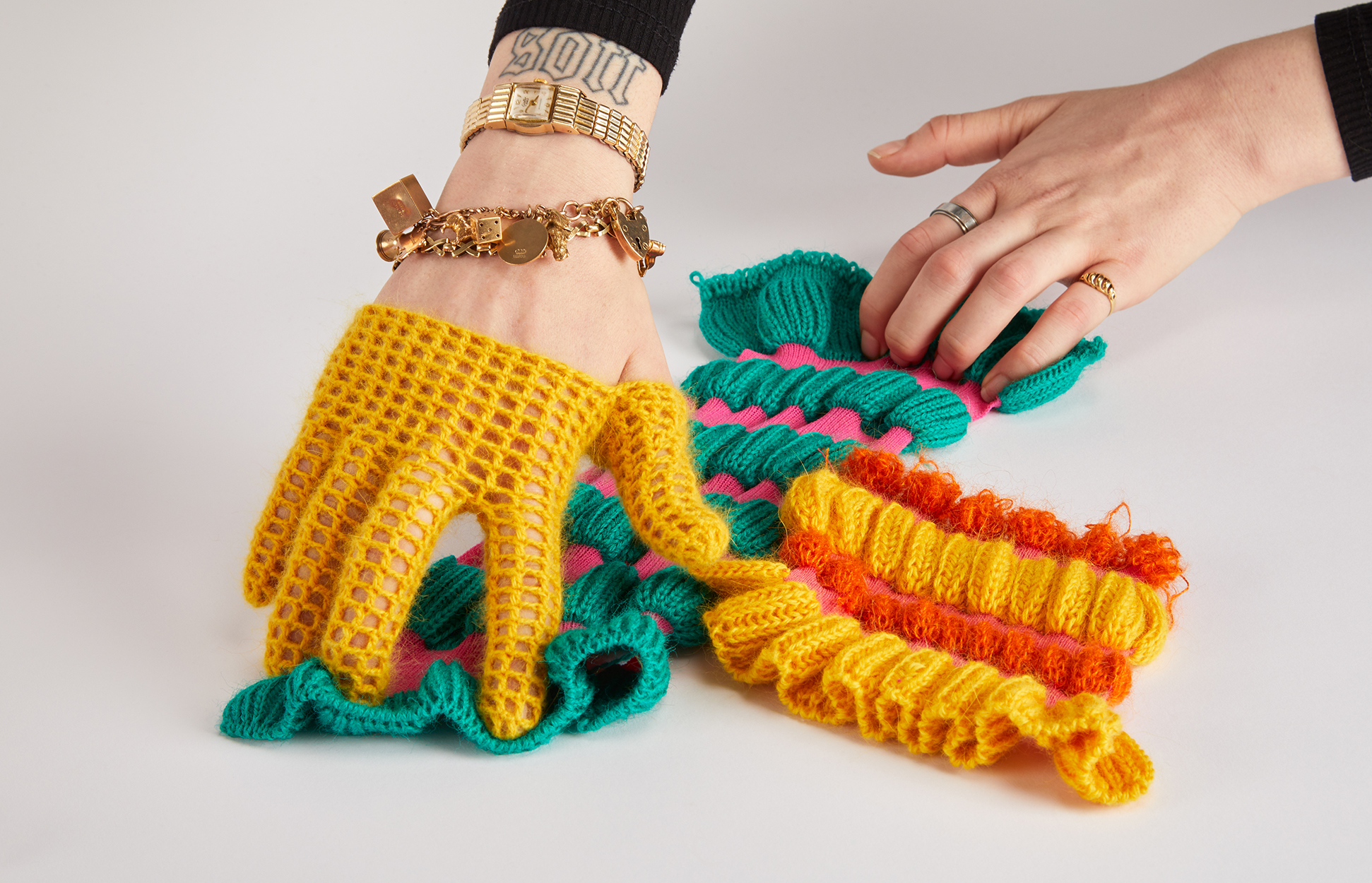 Delicate filet crochet glove interacts with the structural bizzarities of tactile, stretchable knit samples.