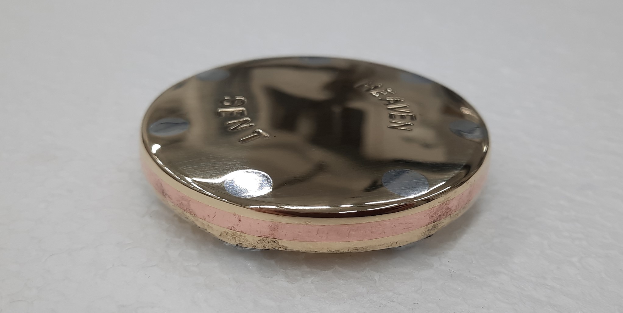 A metal sculpture by Marek Jeczalik. A small Bronze disc with a polished upper, depicts the words 'Heaven Stole'
