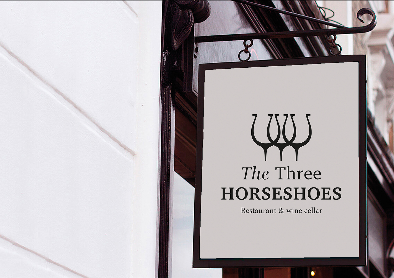 Outdoor swinging sign displaying new horseshoe logo for the restaurant.