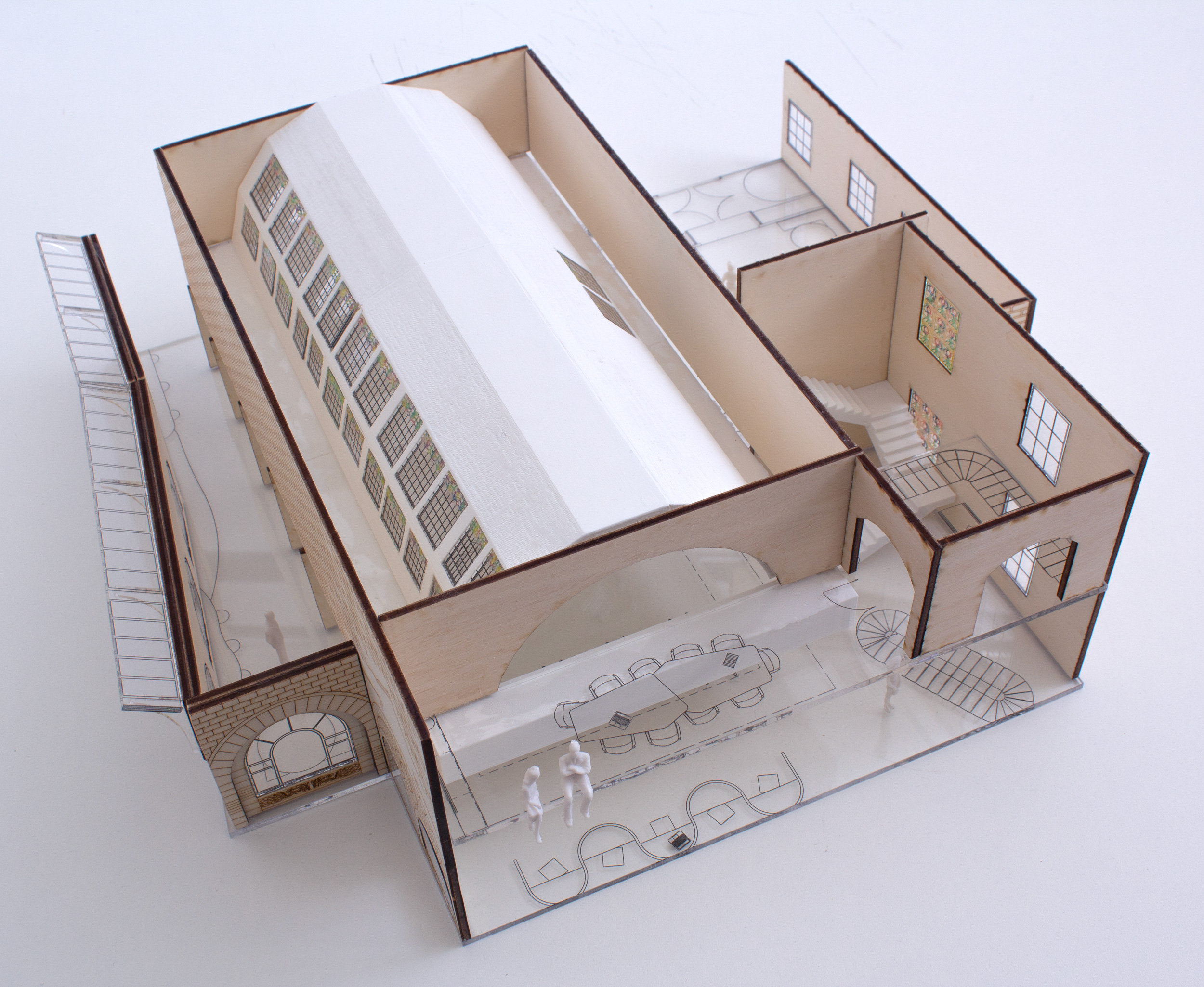 A photograph of a scale model made using laser-cut plywood, clear acrylic, and white 3D printed elements.